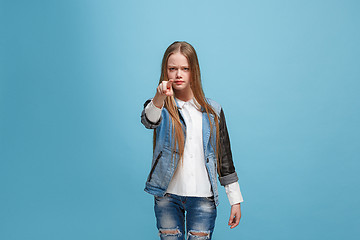 Image showing The happy teen girl pointing to you, half length closeup portrait on blue background.