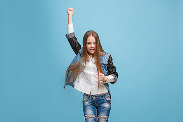 Image showing Happy success teen girl celebrating being a winner. Dynamic energetic image of female model