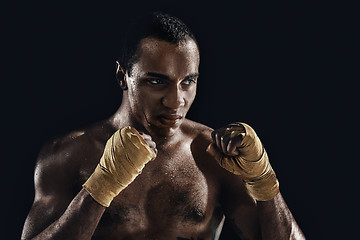 Image showing Afro man boxing and training over black background