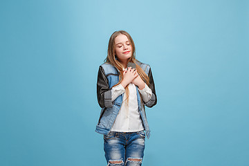 Image showing The happy teen girl standing and smiling against pink background.