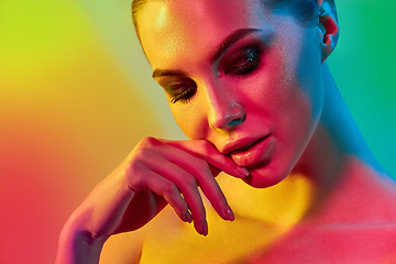 Image showing High Fashion model woman in colorful bright lights posing in studio