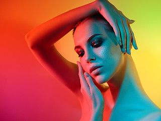 Image showing High Fashion model woman in colorful bright lights posing in studio