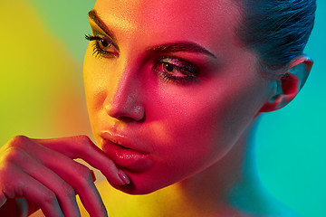 Image showing High Fashion model woman in colorful bright lights posing in studio