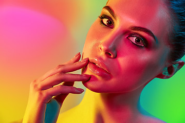 Image showing High Fashion model woman in colorful bright lights posing in studio