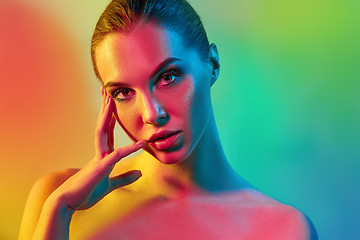 Image showing High Fashion model woman in colorful bright lights posing in studio