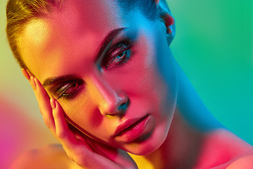 Image showing High Fashion model woman in colorful bright lights posing in studio