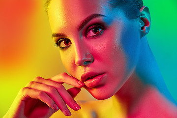 Image showing High Fashion model woman in colorful bright lights posing in studio