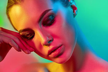 Image showing High Fashion model woman in colorful bright lights posing in studio