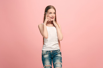 Image showing The happy teen girl standing and smiling against pink background.