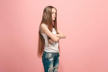 Image showing Portrait of angry teen girl on a pink studio background