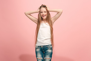 Image showing The happy teen girl standing and smiling against pink background.