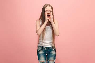 Image showing young casual teen girl shouting at studio