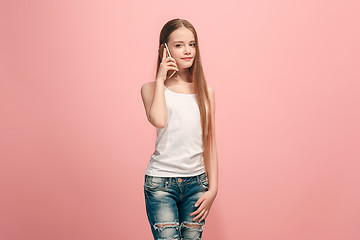 Image showing The happy teen girl standing and smiling against pink background.