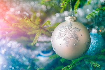 Image showing Christmas-tree decoration bauble on decorated Christmas tree bac