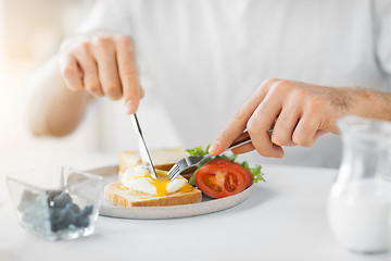 Image showing close up of man having toasts for breakfast
