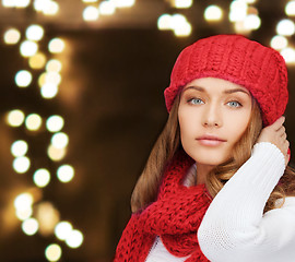 Image showing woman in hat and scarf over lights background