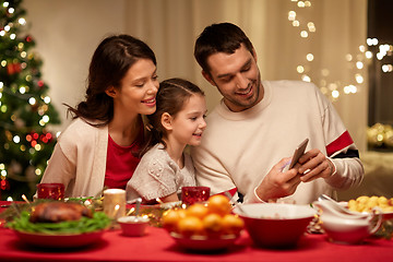 Image showing family with smartphone having christmas dinner