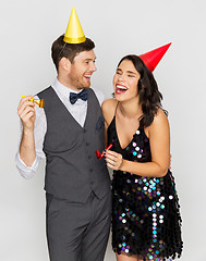 Image showing happy couple with party blowers having fun