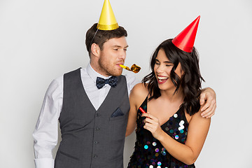 Image showing happy couple with party blowers having fun