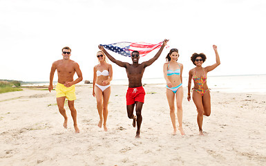 Image showing happy friends with american flag on summer beach