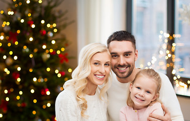 Image showing happy family at home over christmas tree lights