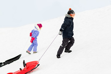 Image showing kids with sleds climbing snow hill in winter