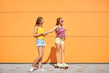 Image showing teenage girls riding skateboard on city street