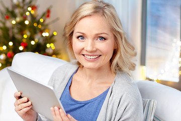 Image showing happy woman with tablet pc at home on christmas