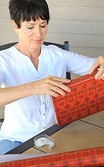 Image showing Female wrapping xmas presents.