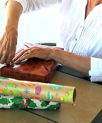 Image showing Female wrapping xmas presents.