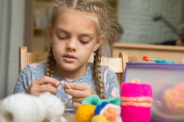 Image showing Portrait of a girl enthusiastically engaged in knitting