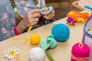 Image showing The girl is engaged in needlework in the classroom