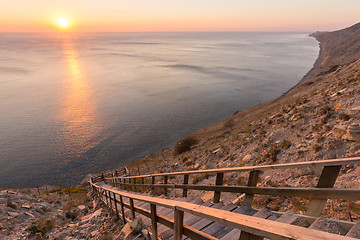 Image showing Ladder going down to the sea on a rocky cliff, sunset, Anapa, Russia