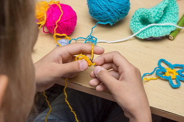 Image showing Hands of a child are embroidered with threads using a hook