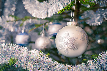 Image showing Christmas-tree decoration bauble on decorated Christmas tree bac