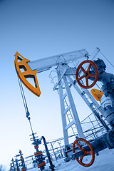 Image showing Oil pump jack and wellhead in the oilfield