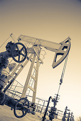 Image showing Oil pump jack and wellhead in the oilfield