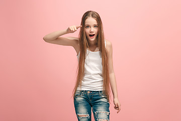 Image showing The happy teen girl pointing to you, half length closeup portrait on pink background.