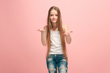 Image showing The happy teen girl offering something against pink background.