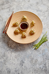 Image showing Delicious chinese dumplings served on wooden plate