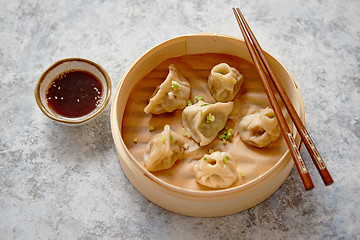 Image showing Delicious chinese dumplings served in wooden bamboo steamer