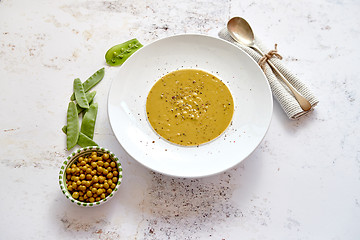 Image showing Creamy soup with green pea in a ceramic white plate