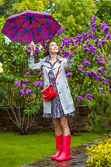 Image showing beautiful woman with an umbrella and in a raincoat