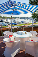 Image showing cafe under a sun umbrella on the shore of yachting