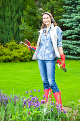 Image showing beautiful smiling middle-aged woman in a flower garden