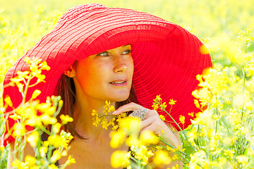 Image showing woman in a red hat on a sunny day amidst wildflowers. portrait, 