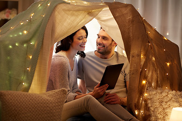 Image showing happy couple with tablet pc in kids tent at home