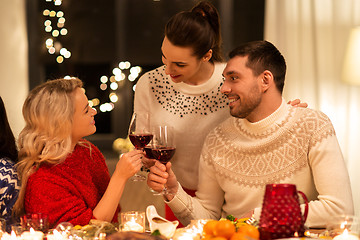 Image showing happy friends drinking red wine at christmas party