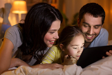 Image showing family with tablet pc in bed at night at home