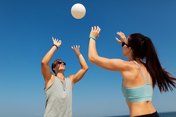 Image showing happy couple playing volleyball on summer beach